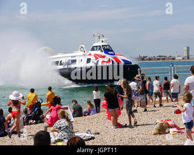 Portsmouth, Regno Unito. 9 lug 2017. Temperature superiori a 24C ha richiamato le famiglie a Southsea Beach in Portsmouth mentre il Portsmouth a Isle of Wight hovercraft azionato dal hoverport sulla spiaggia accanto a loro. Credito: simon evans/Alamy Live News Foto Stock