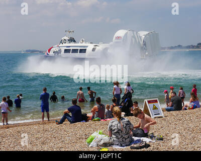 Portsmouth, Regno Unito. 9 lug 2017. Temperature superiori a 24C ha richiamato le famiglie a Southsea Beach in Portsmouth mentre il Portsmouth a Isle of Wight hovercraft azionato dal hoverport sulla spiaggia accanto a loro. Credito: simon evans/Alamy Live News Foto Stock