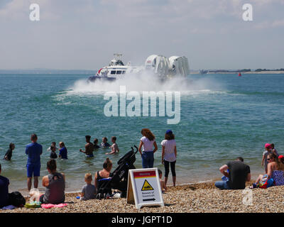 Portsmouth, Regno Unito. 9 lug 2017. Temperature superiori a 24C ha richiamato le famiglie a Southsea Beach in Portsmouth mentre il Portsmouth a Isle of Wight hovercraft azionato dal hoverport sulla spiaggia accanto a loro. Credito: simon evans/Alamy Live News Foto Stock