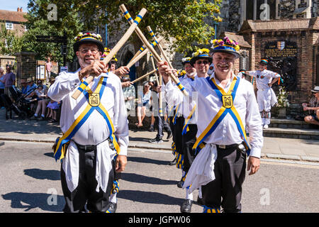 Inglese tradizionale ballerini folk, Yateley Morris lato Dancing in the Street nella città medievale, sandwich durante e folk festival ale. In piedi in due righe, attraversamento di pali di legno. Foto Stock