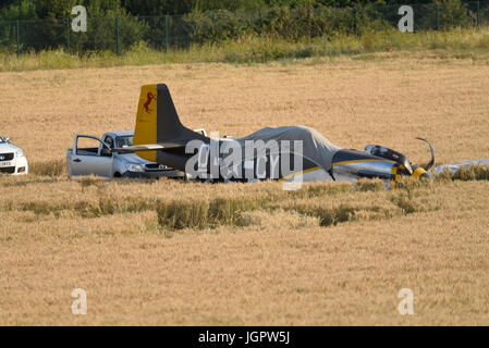 Il pilota di un aereo da combattimento nordamericano P-51 Mustang in tempo di guerra fece un atterraggio forzato di successo in un campo dopo aver subito un guasto al motore al completamento di un'esibizione in un airshow a Duxford Foto Stock