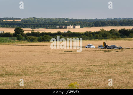 Il pilota di un aereo da combattimento nordamericano P-51 Mustang in tempo di guerra fece un atterraggio forzato di successo in un campo dopo aver subito un guasto al motore al completamento di un'esibizione in un airshow a Duxford Foto Stock