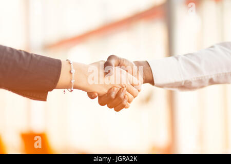 Le persone sul luogo di lavoro: uomo e donna hand shaking in occasione di una riunione Foto Stock