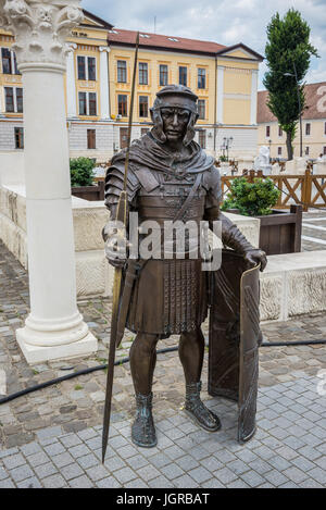 Legionario romano statua in bronzo in accanto alle rovine romane in Alba Carolina fortezza in Alba Iulia città situata nella contea di Alba, Transilvania, Romania Foto Stock