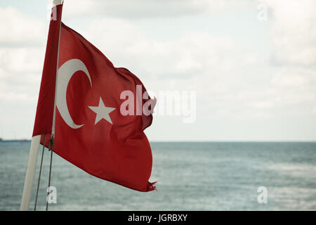 Bandiera turca in barca con acqua di mare in background; Bosforo stretto, Istanbul, Turchia Foto Stock