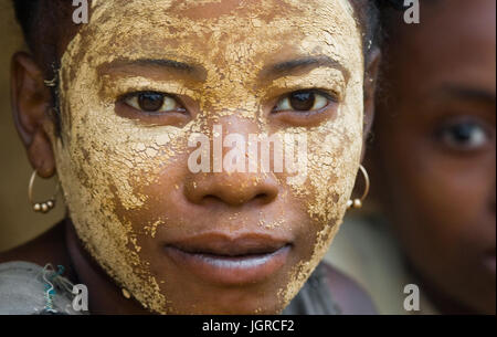 MADAGASCAR, Morondava - Agosto 8, 2011: Ritratto di giovane donna dal villaggio in una maschera di argilla su una faccia. Foto Stock