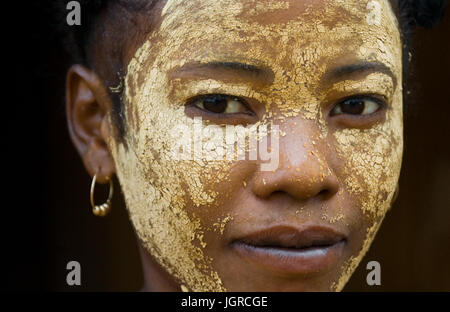 MADAGASCAR, Morondava - Agosto 8, 2011: Ritratto di giovane donna dal villaggio in una maschera di argilla su una faccia. Foto Stock