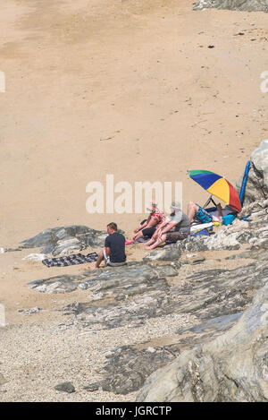 I villeggianti godendo il sole sulla appartata poco Fistral Beach in Newquay, Cornwall. Foto Stock