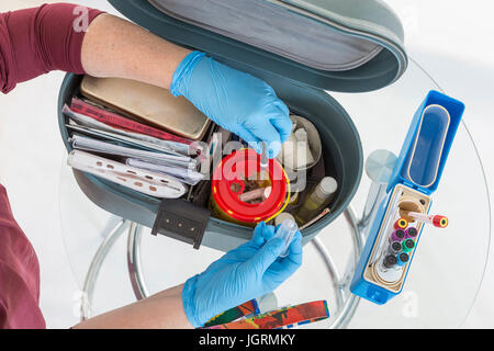 L'infermiera organizzando il suo primo aiuto medico valigetta attrezzi . Le attrezzature di assistenza Foto Stock