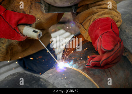 Saldatore con equipaggiamento protettivo esterno di saldatura. Foto Stock