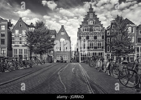 Amsterdam, Paesi Bassi - 30 Ottobre 2016: foto in bianco e nero di biciclette parcheggiate su un ponte che attraversa il Canal Oudezijds Voorburgwal nella Red l Foto Stock