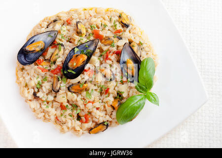 Piatto preparato con cereali misti, riso, scritto e di orzo, con le cozze. Condite con la salsa di pomodoro e il topinambur. Foto Stock