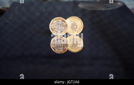 La riflessione di due nuovi due sterlina monete contro sfondo nero (fronte e retro della moneta) Foto Stock