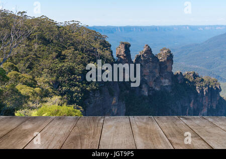 Svuotare tavolo in legno nella parte anteriore di Jamison Valley e formazione rocciosa Tre Sorelle da Echo Point Lookout in Katoomba, Blue Mountains, NSW, Australia. Te Foto Stock