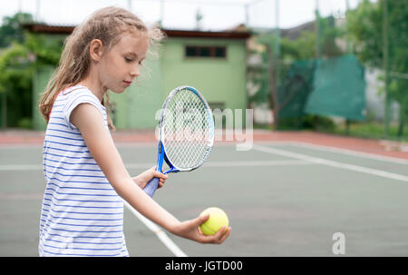 Graziosa bambina giocando a tennis. Foto Stock