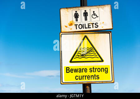 Un segno di avvertimento di forti correnti e dorections per servizi igienici a St Julians Malta Foto Stock