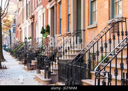 Fila di antichi edifici di arenaria lungo un marciapiede vuoto blocco nel Greenwich Village quartiere di Manhattan, New York New York Foto Stock