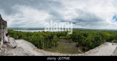 Un uomo godendo la vista dalla cima del tempio IV, Tikal, El Petén, Guatemala. Foto Stock