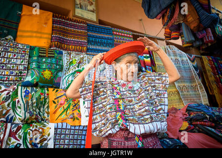 Un vecchio Indegenous Maya della donna che indossa abiti tradizionali, compresa una tocoyal o testa wrap tipico hat di Santiago Atitlan, Guatemala Foto Stock