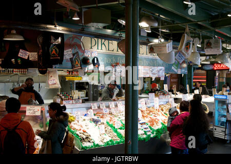 SEATTLE, WASHINGTON, STATI UNITI D'AMERICA - gennaio 24th, 2017: i clienti presso il Pike Place Fish Company attendere per ordinare pesce al famoso mercato di frutti di mare. Questo mercato, aperto nel 1930, è noto per la loro aria aperta al mercato del pesce di stile. Foto Stock