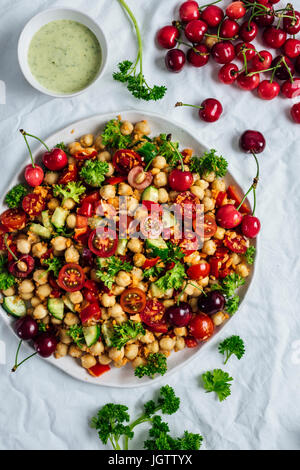 Insalata di ceci con carota tritati, cetrioli e per le ciliegie accompagnati con un curry dressing di yogurt. Foto Stock