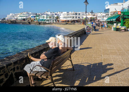 Vecchia coppia su un banco, una passeggiata sul lungomare, Playa Blanca, Lanzarote, Isole canarie, Spagna, Europa Foto Stock
