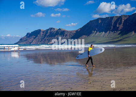 Il corpo del surfista a spiaggia di Famara, Famara montagne, La Caleta de Famara, Lanzarote, Isole canarie, Spagna, Europa Foto Stock