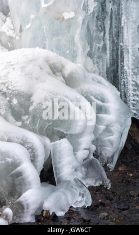 Il gocciolamento di acqua a molla è congelato in forme astratte da temperature sotto zero. Foto Stock