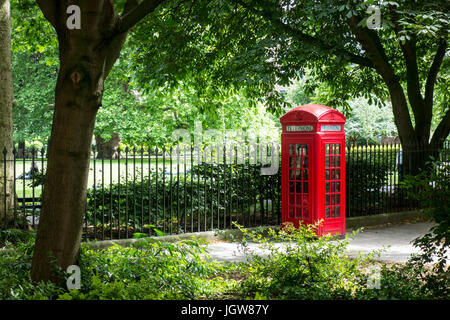 Telefono tradizionale casella al di fuori di Brunswick Square Gardens, London, Regno Unito Foto Stock