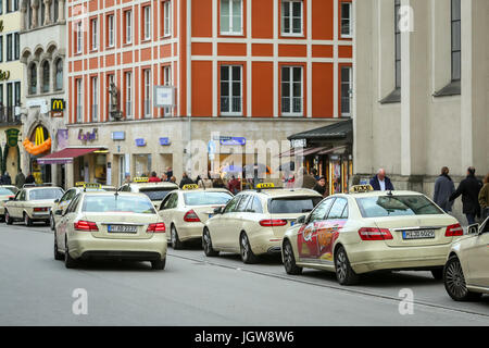 Monaco di Baviera, Germania - 9 Maggio 2017 : la gente a piedi in strada accanto a schierate parcheggiati taxi a Monaco di Baviera, Germania. Foto Stock