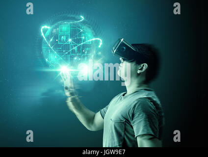 Un giovane uomo che indossa la realtà virtuale (VR) occhiali e cuffia con una proiezione di un mondo digitale. Foto Stock