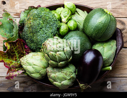 La cottura di sfondo il concetto di raccolto. Organico fresche verdure nella pentola di creta. Foto Stock