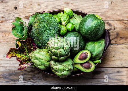 La cottura di sfondo il concetto di raccolto. Organico fresche verdure nella pentola di creta. Foto Stock