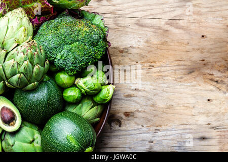 La cottura di sfondo il concetto di raccolto. Organico fresche verdure nella pentola di creta. Foto Stock