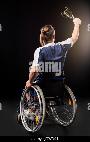 Vista posteriore della seduta paralimpici in sedia a rotelle e campione di contenimento calice isolato su nero Foto Stock