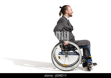 Vista laterale del sorridente imprenditore disabili in carrozzella isolato su bianco Foto Stock