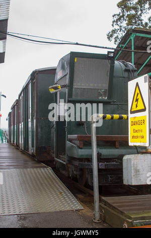 La carreggiata stretta un treno che percorre la lunghezza della Hythe Pier trasporto di passeggeri da e per il traghetto a Southampton presi su un ottuso bagnato estate Foto Stock