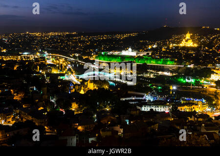 Città di Tbilisi, Georgia, Europa orientale di notte mostra illuminato Cattedrale di Sameba, ponte di pace e Vecchia Tbilisi. Foto Stock