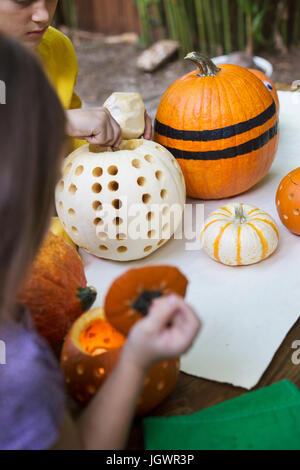 Sulla spalla della ragazza e fratello la preparazione di zucche sul tavolo da giardino Foto Stock