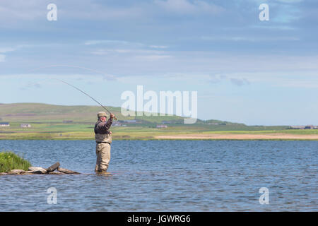 Uomo di Pesca a Mosca Report di Pesca in un loch in Isole Orcadi Scozia UK Foto Stock