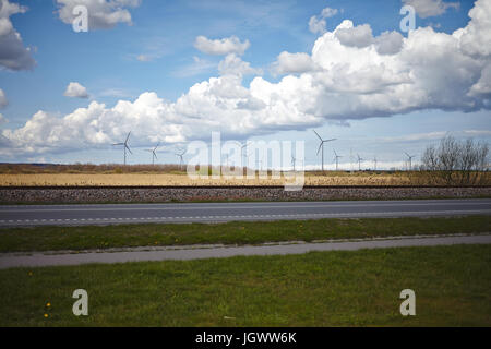 Terreni agricoli, la strada e i binari della ferrovia e wind farm paesaggio in Polonia settentrionale, aprile 2016. Foto Stock