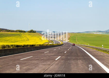 Nuovo di zecca freeway strada in Germania. Autostrada tra verdi campi nel giorno di estate Foto Stock