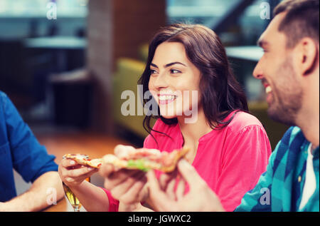 Gli amici di mangiare la pizza con la birra al ristorante Foto Stock