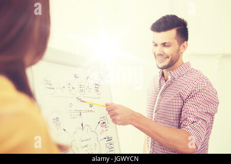 Il team creative con lo schema sul flip board in ufficio Foto Stock