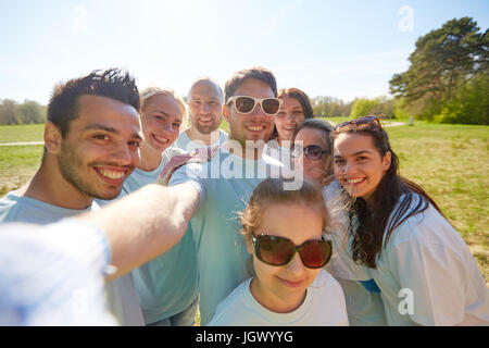 Un gruppo di volontari che assumono selfie tramite smartphone Foto Stock