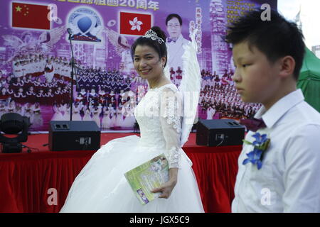 Hong Kong, Cina. 11 Luglio, 2017. Una donna cinese vestito come angelo a piedi passato durante la fase continua festa per celebrare il ventesimo anniversario di Hong Kongs handover alla Cina. Luglio 11, 2017. Hong Kong.ZUMA/Liau Chung Ren Credito: Liau Chung Ren/ZUMA filo/Alamy Live News Foto Stock