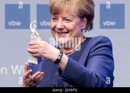 Monaco di Baviera, Germania. 11 Luglio, 2017. dpatop - il Cancelliere tedesco Angela Merkel detiene una statua della Baviera al bavarese colloqui economici (Bayerisches Wirtschaftsgespraech) di Monaco di Baviera, Germania, 11 luglio 2017. Merkel corrente affrontate sfide politiche al trentanovesimo bavarese colloqui economici. Foto: Alexander Heinl/dpa/Alamy Live News Foto Stock