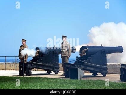 I soldati sparare cannoni per il cannone di mezzogiorno in Upper Barrakka Gardens, La Valletta, Malta, l'Europa. Foto Stock