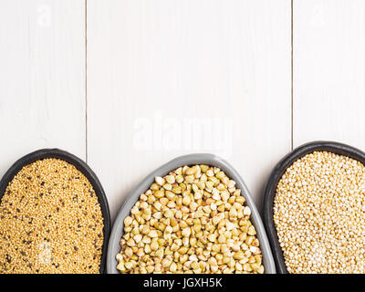 Il verde del grano saraceno, i semi di amaranto e quinoa nel quartiere alla moda di piastre bianche su un tavolo di legno. Superfoods concetto. Vista superiore piatta o laici. Copia dello spazio. Foto Stock