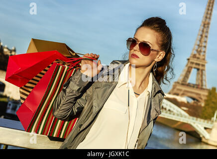 Ottieni il tuo sacchetti pronti per la Parigi d'autunno. vendita moda giovane-monger con shopping bags guardando in lontananza vicino a Torre Eiffel Foto Stock